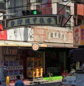 a traffic light in front of a building with writing on it at Fengjia AS House in Taichung