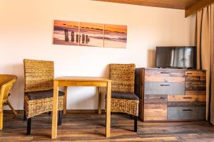 Zimmer mit einem Tisch und Stühlen sowie einem TV in der Unterkunft Steinbühler Hof - Stressfrei am Lande in Bad Koetzting