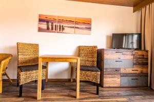 een kamer met een tafel en stoelen en een televisie bij Steinbühler Hof - Stressfrei am Lande in Bad Koetzting