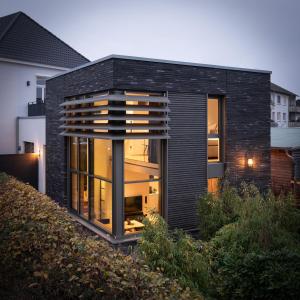 une maison noire avec beaucoup de fenêtres dans l'établissement Boarding Cube Oldenburg, à Oldenbourg