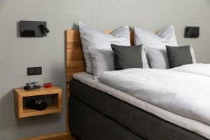 a bedroom with a bed with white sheets and pillows at Boarding Cube Oldenburg in Oldenburg