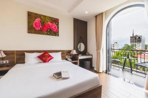 1 dormitorio con 1 cama grande y balcón en City Center Rosa Hotel en Phu Quoc