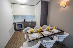 Un comedor con una mesa y sillas blancas. en SuperApartment, en Poiana Brasov