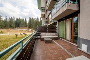un balcón de un edificio con un sofá en SuperApartment, en Poiana Brasov
