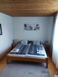 a large bed in a bedroom with a wooden ceiling at Hotel & Pension Haus Dewenter in Lichtenau
