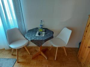 una mesa con dos sillas y una botella de agua. en Hotel & Pension Haus Dewenter, en Lichtenau