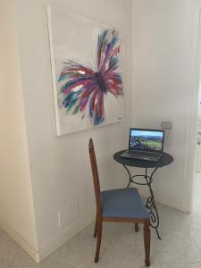 een tafel met een laptop op een tafel met een stoel bij A Casa di Anna in Mamoiada