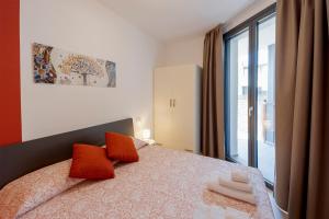 een slaapkamer met een bed met oranje kussens en een raam bij Aregai Marina Exclusive Seaside Apartments in Santo Stefano al Mare