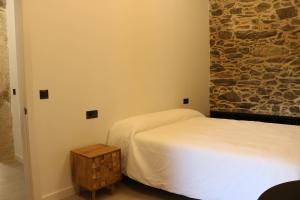 sypialnia z 2 łóżkami i kamienną ścianą w obiekcie O lar de San Fins-Casita rural w mieście A Coruña