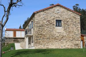 un edificio de piedra con una ventana en el lateral. en O lar de San Fins-Casita rural, en A Coruña
