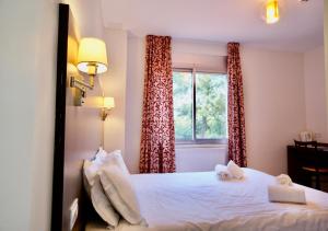 a bedroom with a bed and a window with curtains at Hôtel Restaurant Le Sainte Marguerite in Pornichet