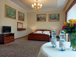 ein Hotelzimmer mit einem Bett und zwei Flaschen auf dem Tisch in der Unterkunft Victoria Cechini in Krynica-Zdrój