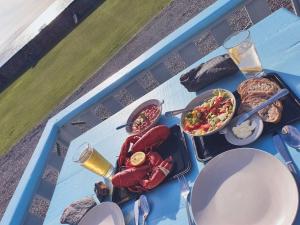 una mesa azul con una bandeja de comida. en Dolphin View Cottages en Portmahomack