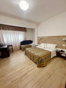 a hotel room with two beds and a desk at Hotel La Bussola in Anzio