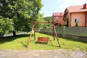 a park with a wooden swing set in a yard at Cottage Wellwood in Sinyak
