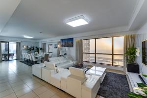 una sala de estar con muebles blancos y vistas al océano. en Dubai Jbr Amazing Penthouse With Stunning View, en Dubái