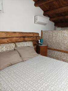 a bedroom with a bed and a wooden headboard at Piccola Azzurra in Comiso