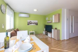 - un salon avec des murs verts et une table dans l'établissement Apartment Salvagno, à Punat