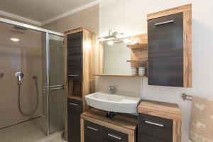 La salle de bains est pourvue d'un lavabo et d'une douche. dans l'établissement Apartment Salvagno, à Punat