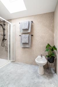 y baño con aseo, ducha y toallas. en Penzion Vinařství W18, en Velké Bílovice