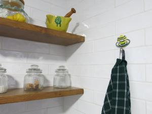 a bathroom with white tiled walls and wooden shelves at Casa Sant Vicent 63 in Teulada +73 photos
