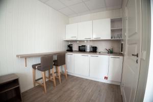 a kitchen with white cabinets and a table and chairs at Askvoll Fjordhotell in Ask