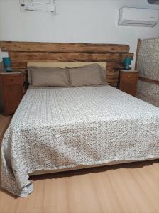 a bedroom with a bed with a wooden headboard at Piccola Azzurra in Comiso
