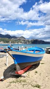 un bateau bleu assis sur le sable sur une plage dans l'établissement VacanzeNaxos - Casa Frontemare, à Giardini Naxos