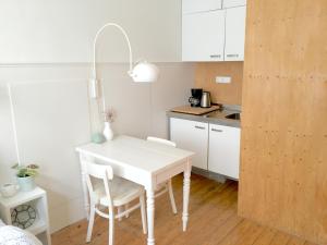 a white kitchen with a white table and chairs at guestroom traza 37 in Amsterdam