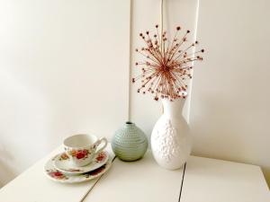 a table with a vase and a cup and a plate at guestroom traza 37 in Amsterdam