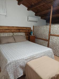 sypialnia z łóżkiem i drewnianym sufitem w obiekcie Piccola Azzurra w mieście Comiso