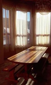 a wooden table sitting in front of two windows at Cottage Wellwood in Sinyak