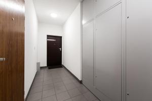 um corredor com paredes brancas e uma porta preta em SuperApart Banderii 4 em Varsóvia