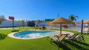 a swimming pool with chairs and an umbrella at Casa Serrano Cártama by Ruralidays in Cártama