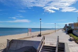 a boardwalk on a beach next to the ocean at Beachfront House, Valencia, Wifi, Paddle Surf Board, Incredible Views in Sueca