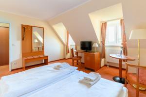 a hotel room with a bed and a television at Nordsee-Hotel Arlau-Schleuse in Husum