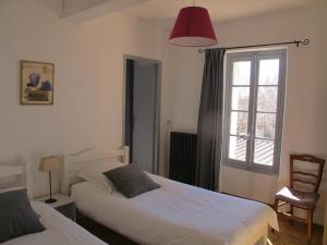 a bedroom with two beds and a window at Le Guintrand in Bédoin