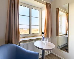 Zimmer mit einem Tisch und einem Fenster in der Unterkunft Nordsee-Hotel Arlau-Schleuse in Husum