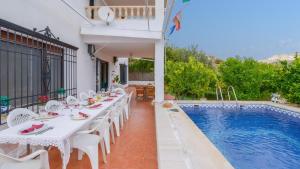 a dining table and chairs next to a swimming pool at Casa Rural Parador del Silo Cónchar by Ruralidays in Granada