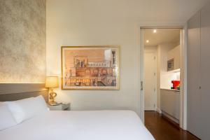 a hotel room with a bed and a lamp at Duquesa Suites Barcelona in Barcelona