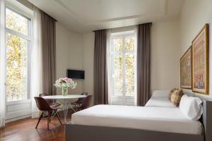 Säng eller sängar i ett rum på Duquesa Suites Landmark Hotel by Duquessa Hotel Collection