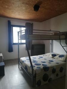 a bedroom with a bunk bed and a window at LE FRUIT A PAIN in Saint-Joseph