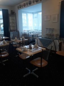 ein Esszimmer mit Tischen und Stühlen in einem Restaurant in der Unterkunft Newton House in Torquay