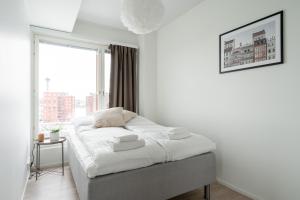 een bed in een kamer met een groot raam bij 2ndhomes Tampere "Kaplan #1" Grand Luxury Apartment - Sauna & Balconies in Tampere