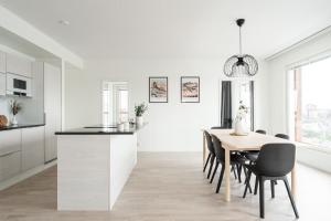 een keuken en eetkamer met een tafel en stoelen bij 2ndhomes Tampere "Kaplan #1" Grand Luxury Apartment - Sauna & Balconies in Tampere