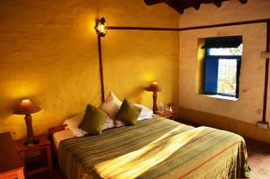 una camera con un letto, due lampade e una finestra di Thikalna Himalayan Retreat ad Almora