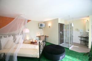 Schlafzimmer mit Himmelbett und Bad in der Unterkunft Hotel Am Hirschhorn - Wellness - Spa - and more in Wilgartswiesen