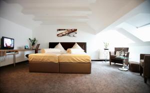 a bedroom with a bed and a living room at Hotel Am Hirschhorn - Wellness - Spa - and more in Wilgartswiesen