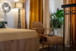 um quarto com uma cama, uma cadeira e uma planta em Green Symi Apartment em Simi