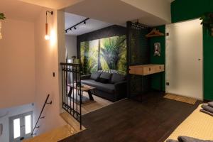 uma sala de estar com um sofá preto e paredes verdes em Green Symi Apartment em Simi